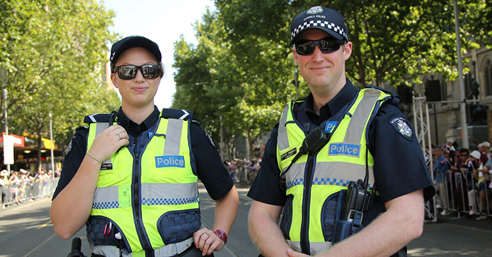Two police officers smiling at a camera